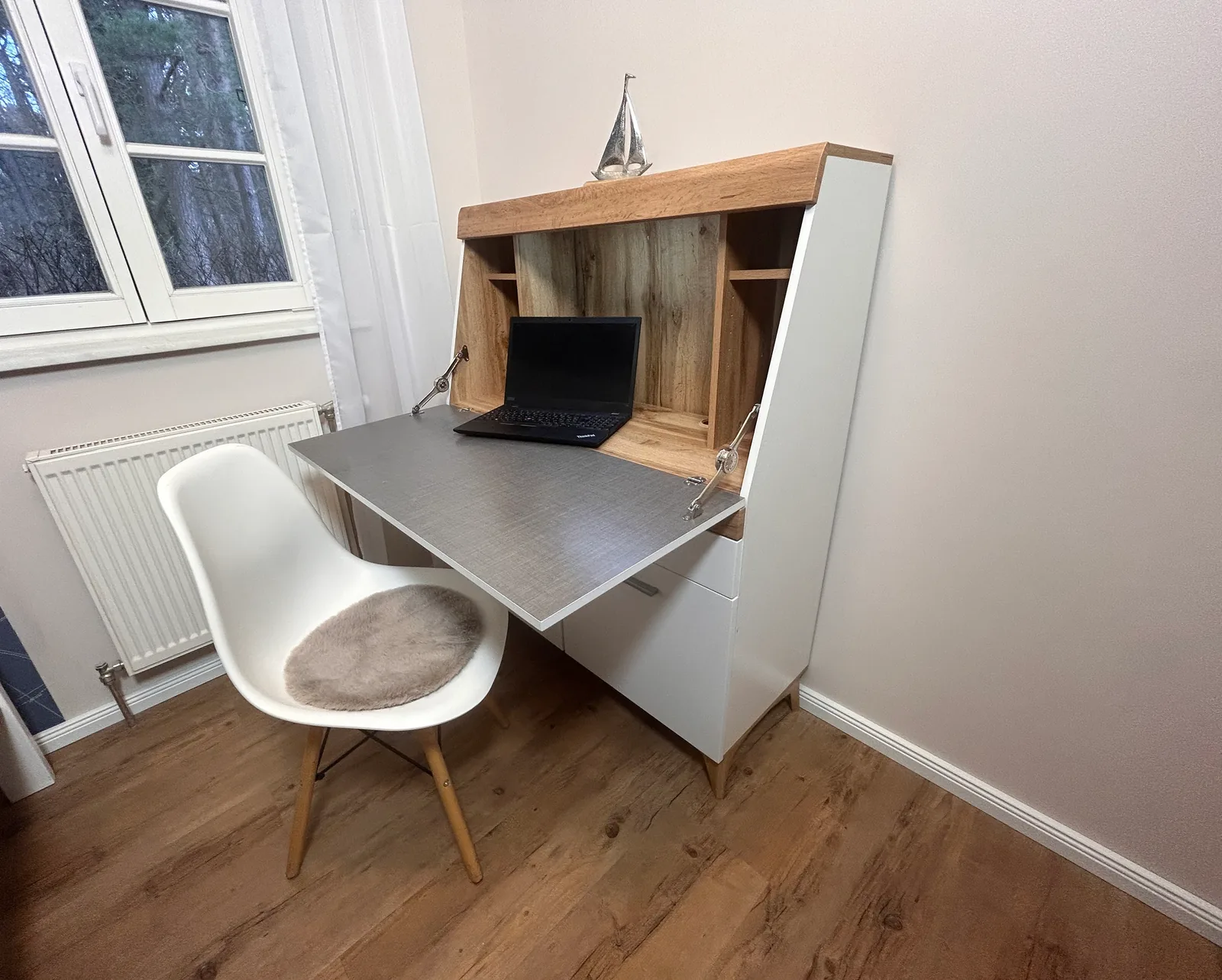 Kleiner Arbeitsplatz mit Sekretär, Laptop und Stuhl am Fenster