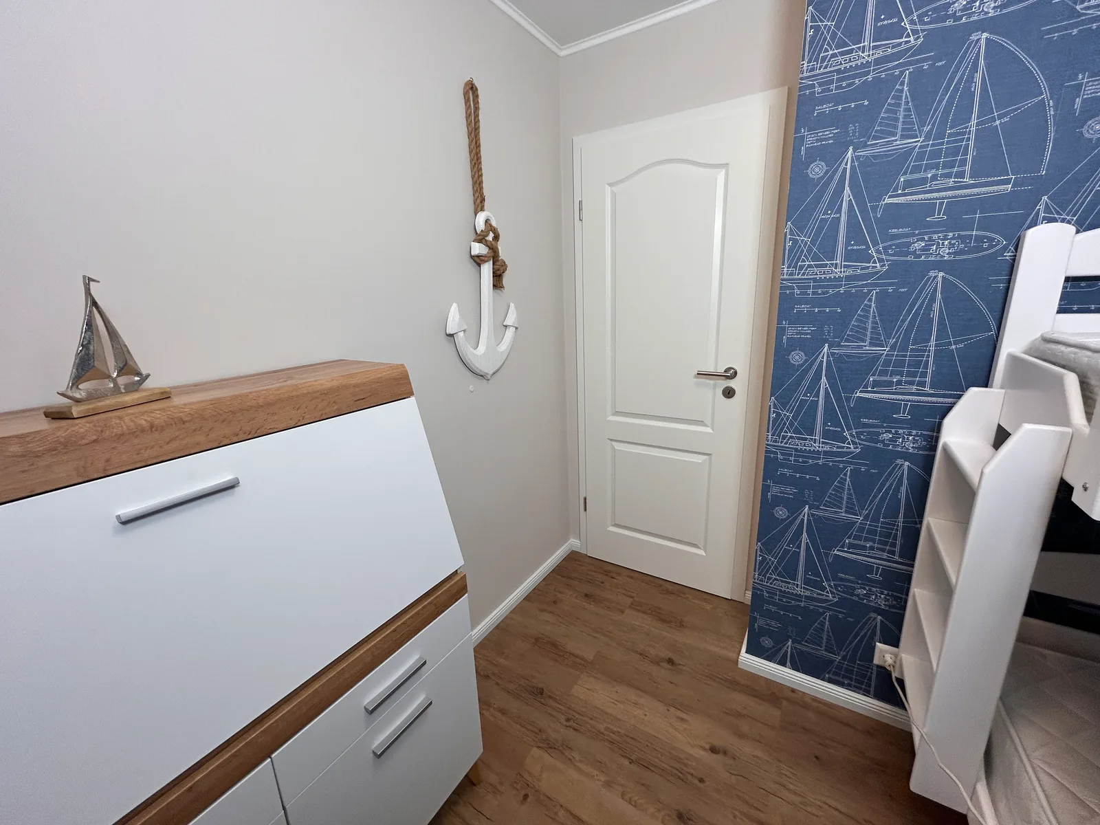 Kommode und maritime Dekoration neben dem Etagenbett