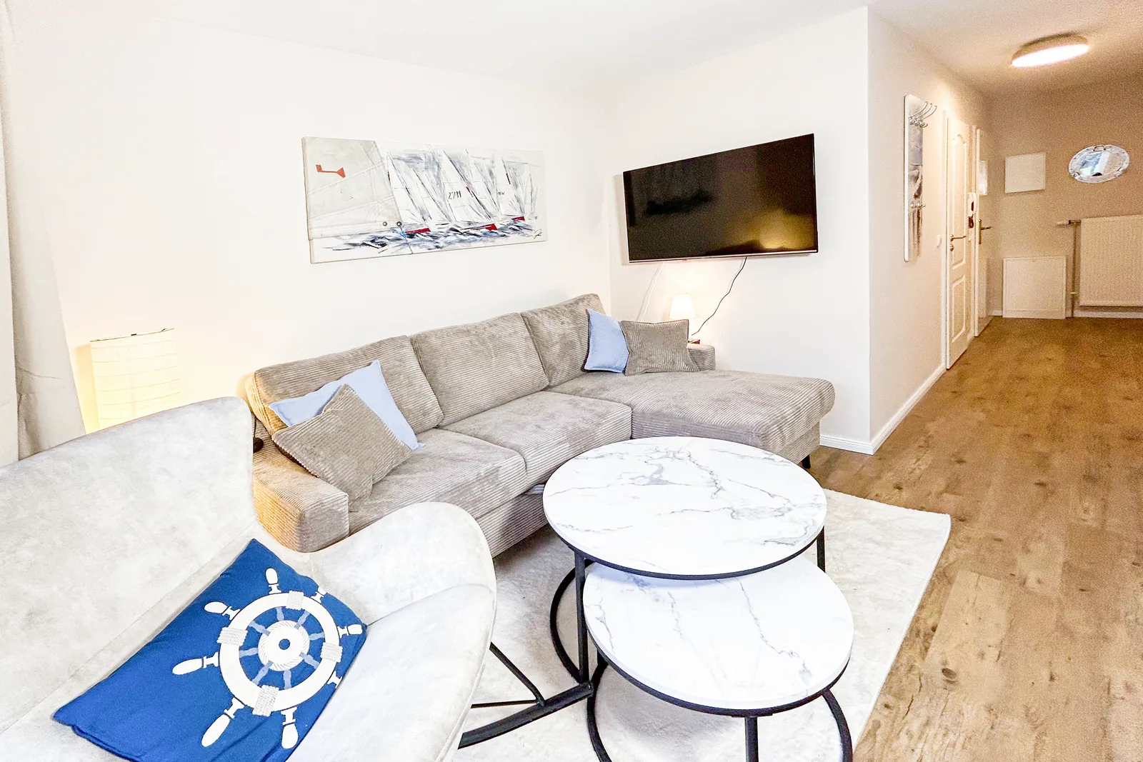 Wohnbereich mit Ecksofa, Couchtischen, Schaukelstuhl und Fernseher