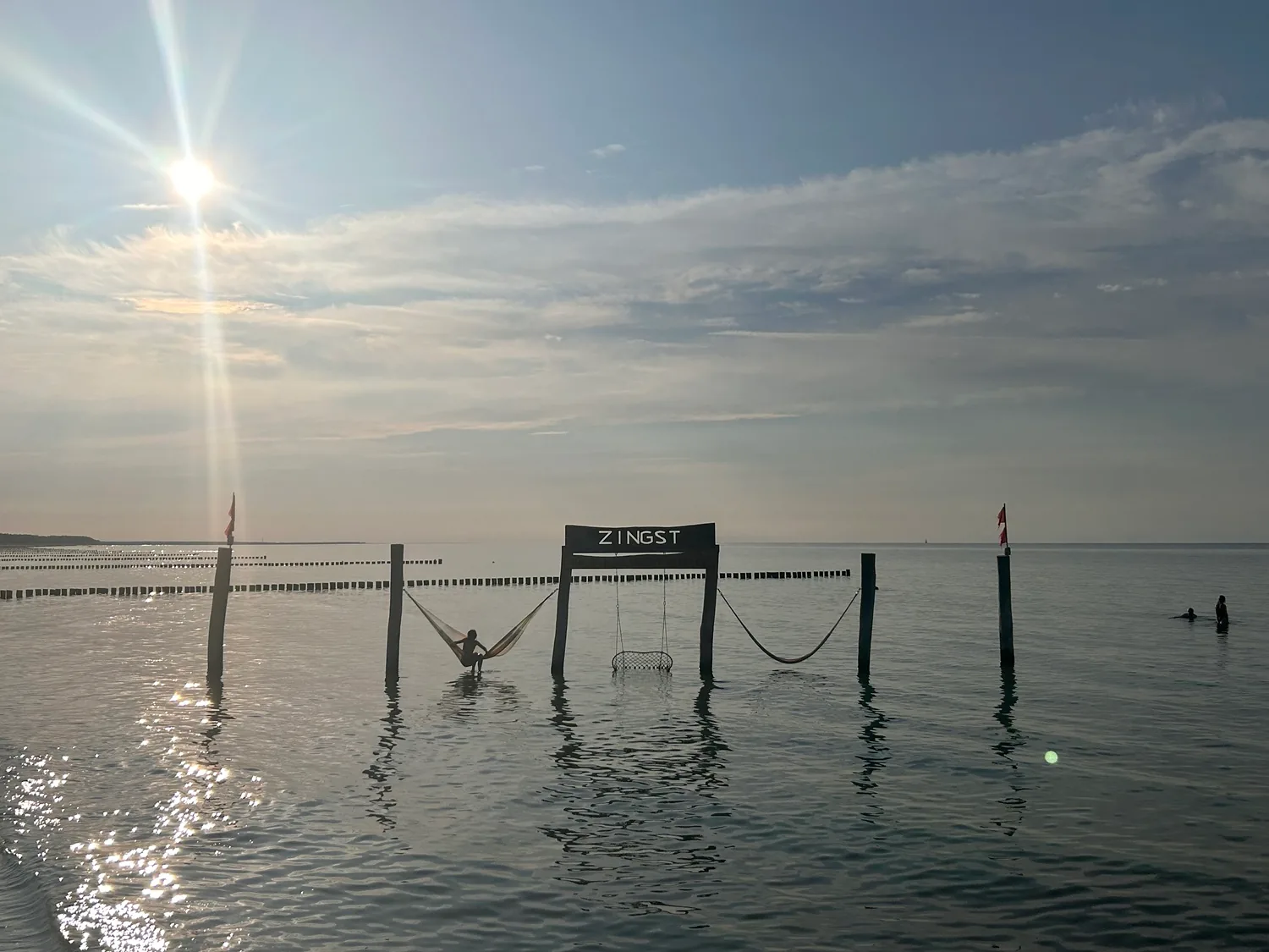 Schaukel im Wasser mit Zingst-Schild im tief stehenden Sonnenlicht