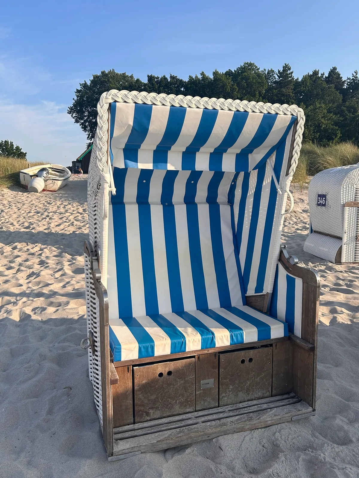 Blau-weißer Strandkorb im Sand am Ostseestrand